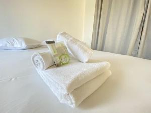 uma pilha de toalhas sentadas em cima de uma cama em Grand studio, belle terrasse avec vue em Nantes