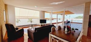 sala de estar con mesa, sillas y TV en Bright 4 bedroom Villa, Pool and Tennis court, en Playa Paraiso