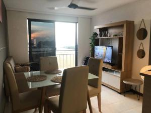 comedor con mesa, sillas y TV en Hermoso apartamento con piscina, vista al mar #, en Santa Marta