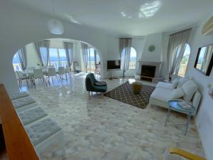 sala de estar con muebles blancos y chimenea en MIRAMAR, en Cumbre del Sol
