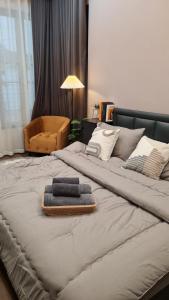 a bed with two towels and a chair on it at บ้านเซฟโซน in Ban Nong Hin