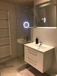La salle de bains est pourvue d'un lavabo blanc et d'un miroir. dans l'établissement Ferienwohnung Burg Freienstein Blick 4 Sauna, à Gammelsbach