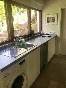 a kitchen with a sink and a washing machine at Ferienwohnung Burg Freienstein Blick 4 Sauna in Gammelsbach