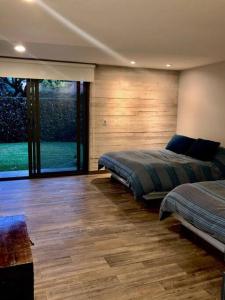 - une chambre avec 2 lits et une grande fenêtre dans l'établissement CASA MOSHI, à Malinalco