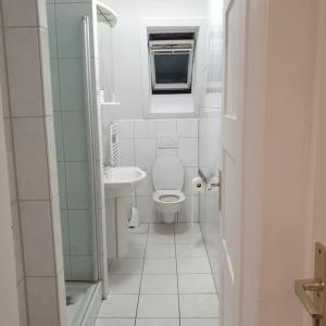 een witte badkamer met een toilet en een wastafel bij Schöne geräumige 3 Zimmer Wohnung in Heidelberg in Leimen