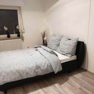 een slaapkamer met een bed met kussens en een raam bij Schöne geräumige 3 Zimmer Wohnung in Heidelberg in Leimen