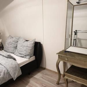 een slaapkamer met een spiegel, een bed en een tafel bij Schöne geräumige 3 Zimmer Wohnung in Heidelberg in Leimen