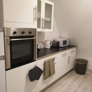 eine Küche mit einem Herd und einer Mikrowelle in der Unterkunft Schöne geräumige 3 Zimmer Wohnung in Heidelberg in Leimen