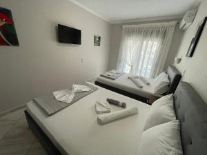 two beds sitting in a room with a window at Studios Megas Alexandros in Nea Vrasna
