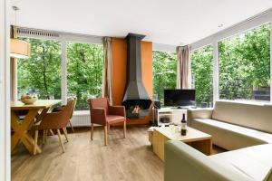 sala de estar con sofá y chimenea en Summio Parc Heihaas, en Putten