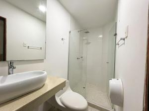 uma casa de banho com um WC e uma cabina de duche em vidro. em Hotel Barranquilla Prado em Barranquilla