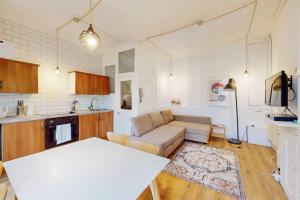 a kitchen and living room with a couch and a table at Modern 2 Bed Maisonette in Farringdon Barbican in London