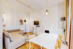 a living room with a white couch and a table at Modern 2 Bed Maisonette in Farringdon Barbican in London