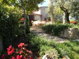 een tuin met stoelen en bloemen voor een huis bij SCAPPO IN UMBRIA, la casa di Giuliana in Lugnano in Teverina
