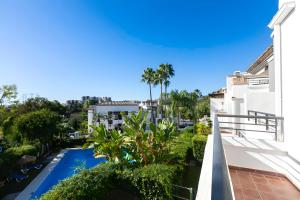 a view of the pool from the balcony of a apartment at El Lago de Los Arqueros, Benahavís in Benahavís