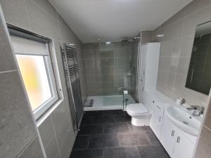 a bathroom with a toilet and a sink and a tub at Bruxie Holiday Cottages - River Cottage in Maud