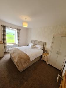 A bed or beds in a room at Bruxie Holiday Cottages - River Cottage