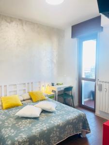 - une chambre avec un grand lit et des oreillers jaunes dans l'établissement Smart Design Apartment Central Station, à Bergame