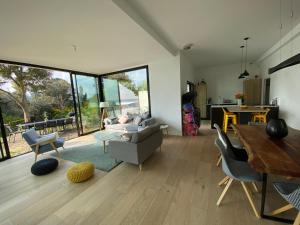 ein Wohnzimmer mit einem Sofa und einem Tisch in der Unterkunft Vue mer Bretagne Villa d'architecte in Plérin