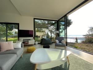 een woonkamer met een bank en een tafel bij Vue mer Bretagne Villa d'architecte in Plérin