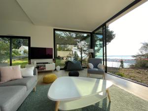 un soggiorno con un divano e un tavolo di Vue mer Bretagne Villa d'architecte a Plérin