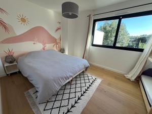 a bedroom with a bed and a large window at Vue mer Bretagne Villa d'architecte in Plérin +45 photos