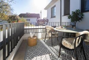a patio with a table and chairs on a balcony at Kolibri Apartment in Elsbethen