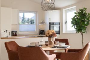 a kitchen and dining room with a table and chairs at Kolibri Apartment in Elsbethen