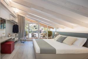 a bedroom with a large bed and a dining room at Hotel Continental - TonelliHotels in Nago-Torbole