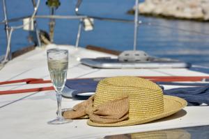 a straw hat and a glass of water on a table at Sun odyssey 43ib in Corfu Town