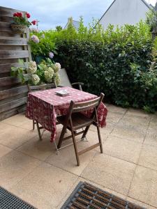 une table et une chaise avec une table et des fleurs dans l'établissement Studio récent Cosy - Ploemeur, à Ploemeur