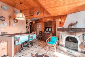 una cucina con camino, tavolo e sedie di La Mansarda di Prato Nevoso a Prato Nevoso