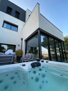 una vasca idromassaggio di fronte a una casa di Vue mer Bretagne Villa d'architecte a Plérin