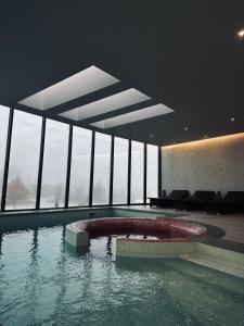 een grote kamer met een zwembad in een gebouw met ramen bij Grapple Hotel & Spa in Carrazeda de Anciães