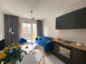 salon z niebieską kanapą i stołem w obiekcie Apartamenty Fuzja - Komfortowe Mieszkania Blisko Centrum Łodzi w Łodzi