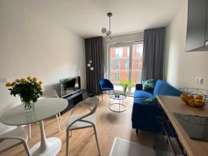 a living room with a blue couch and a table at Apartamenty Fuzja - Komfortowe Mieszkania Blisko Centrum Łodzi in Łódź