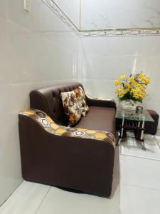 un sofá de cuero marrón en una habitación con mesa en Nhà nghỉ Trung Hiếu 1, en Bình Thủy