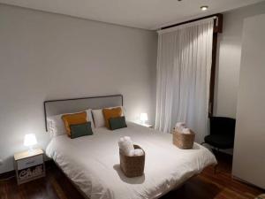 a bedroom with a large white bed with two lamps at City Central By Sleep In Bilbao in Bilbao