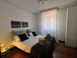1 dormitorio con 2 camas y ventana en City Central By Sleep In Bilbao en Bilbao