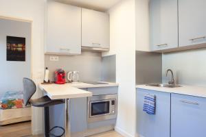 eine Küche mit weißen Schränken und einer Arbeitsplatte in der Unterkunft Appartement Cassis in Cassis