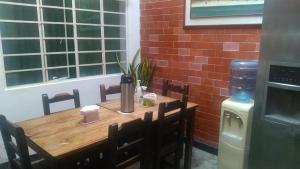 a wooden table with chairs next to a brick wall at Casa San Alonso in Bucaramanga