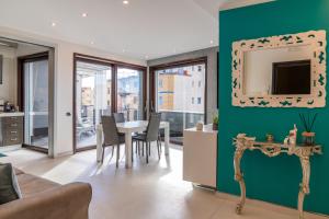 un soggiorno con tavolo e parete verde di Nettuno's Suite a Napoli