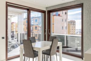 una sala da pranzo con tavolo e sedie bianchi di Nettuno's Suite a Napoli