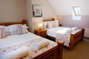 a bedroom with two beds with white sheets at Sycamore Tree Barn in Brecon