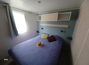 un dormitorio con una cama azul con sombrero en Ma pause Charentaise en Les Mathes