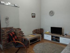 a living room with a tv and a brick wall at Family Stay in Lviv (2 Rooms + Kitchen) in Kulʼparkuv