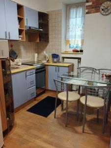a kitchen with a glass table and chairs at Family Stay in Lviv (2 Rooms + Kitchen) in Kulʼparkuv