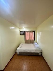 Edgar's Guest House في موالبوال: غرفة نوم صغيرة بها سرير ونافذة