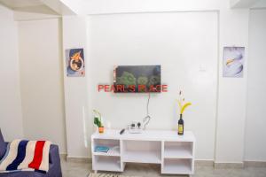 a white bathroom with a sink in a room at Pearl's Place in Meru