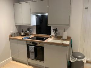 een keuken met witte kasten en een fornuis met oven bij One Bedroom Apartment in Bethesda in Bangor
